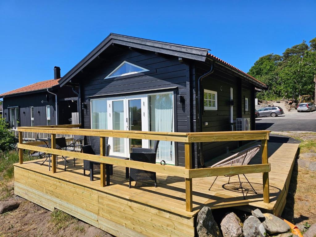 a black tiny house with a large deck at Attefallshus Nära Havet Norranäs in Varberg