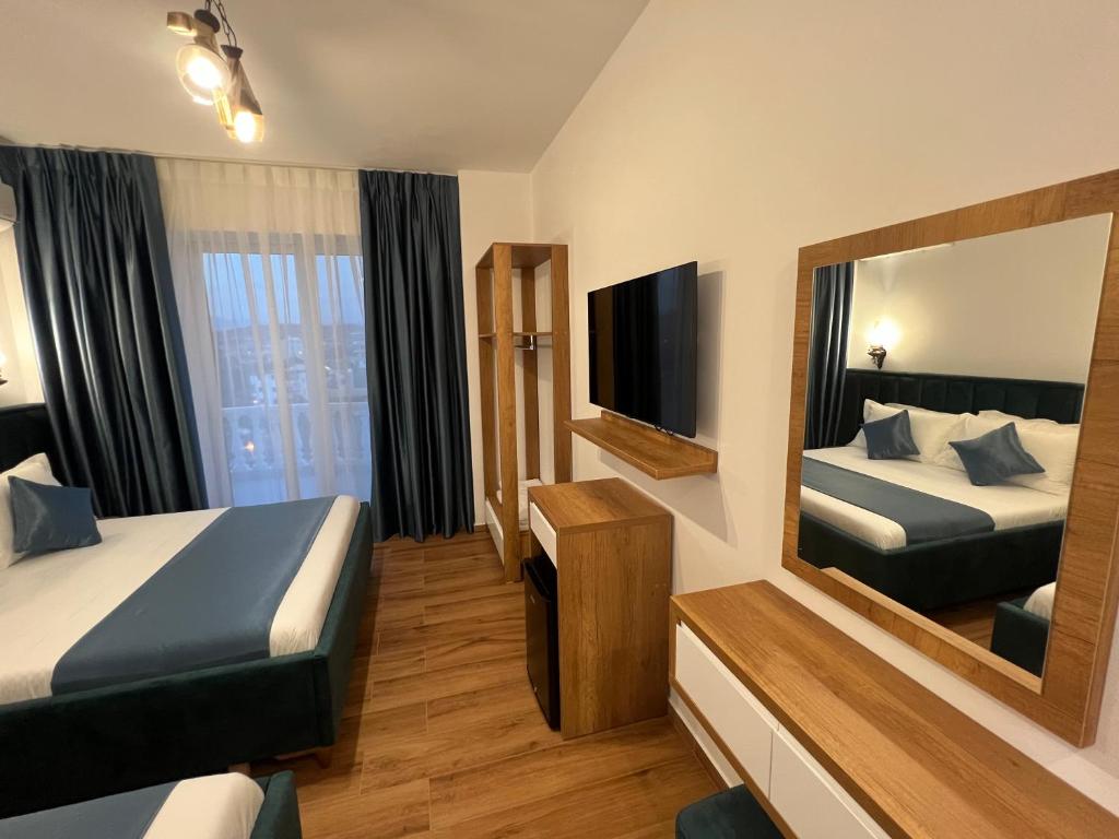 Pokój hotelowy z 2 łóżkami i lustrem w obiekcie ILLYRIAN hotel w mieście Ksamil