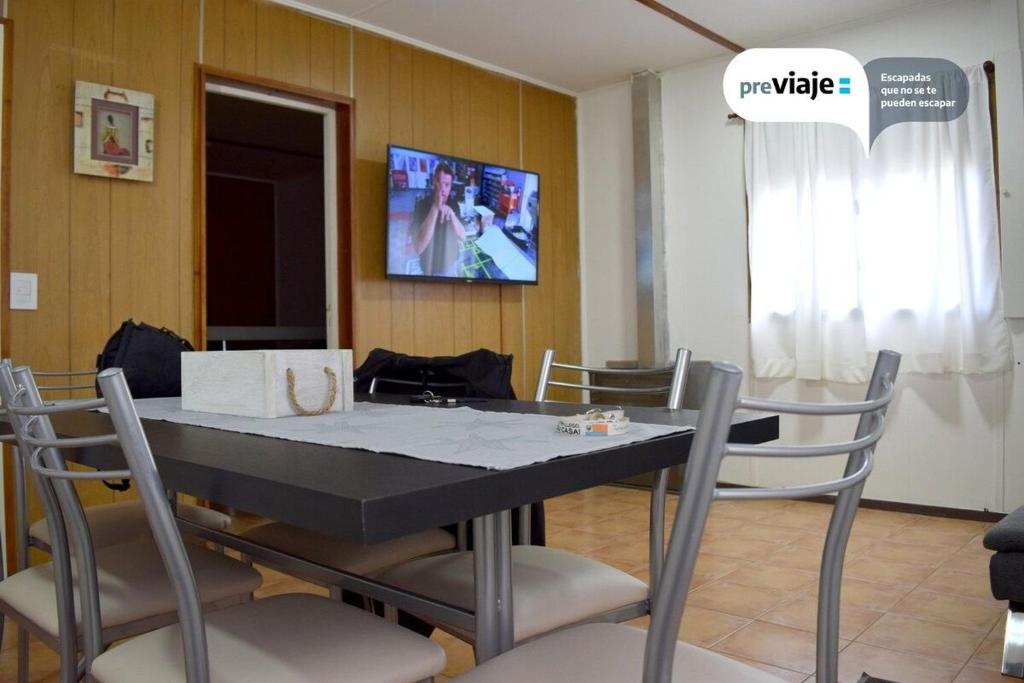 - une salle à manger avec une table, des chaises et une télévision dans l'établissement Silvia's house, à Ushuaia