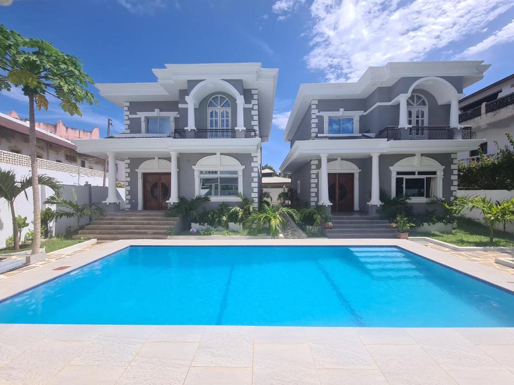 a house with a swimming pool in front of it at Linda's Little Lincoln in Watamu