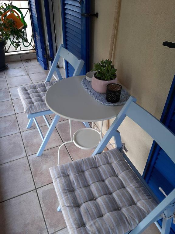 a table and chairs on a balcony with a potted plant at Theros Apartment in Spartokhórion