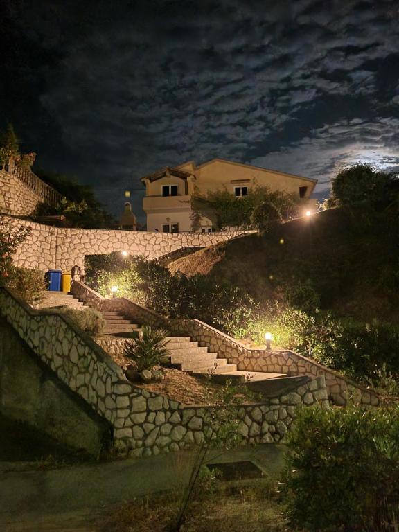 a stone staircase leading up a hill at night at Mariva Apartments in Lopar