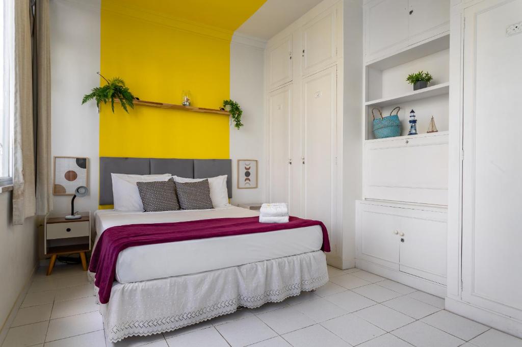1 dormitorio con 1 cama grande y pared amarilla en Conforto em Ipanema - 2 quadras da praia - VP604 Z1, en Río de Janeiro