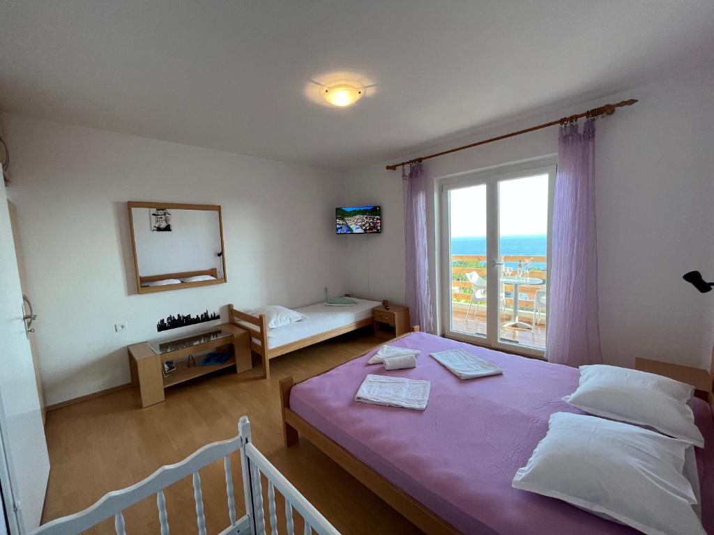 伊萬多拉克的住宿－Apartmani "Nikola" Seaview - Ivan Dolac, Hvar，一间卧室设有一张床和一个大窗户