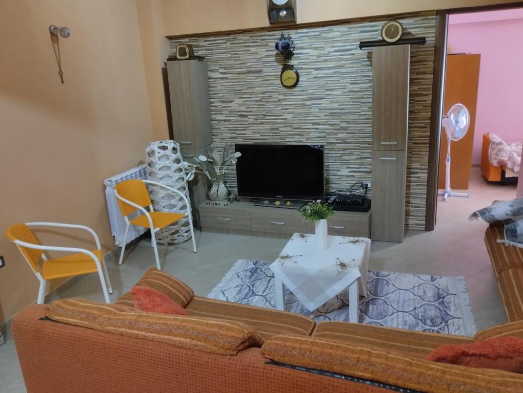 een woonkamer met een bank en een tv bij Casa lungo mare a Thesaloniki in Thessaloniki