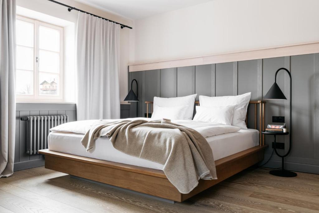 um quarto com uma cama grande e uma cabeceira cinzenta em Refugium Lunz em Lunz am See