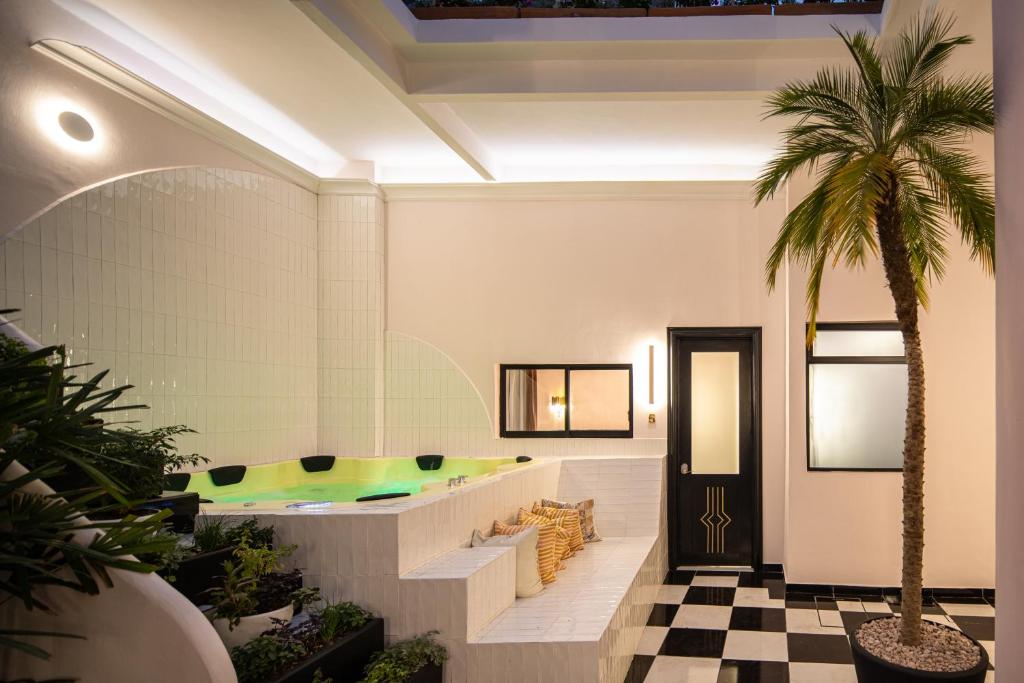 um átrio com uma banheira e uma palmeira em HOLT Hotel De Mi Independencia King Room em Oaxaca de Juárez