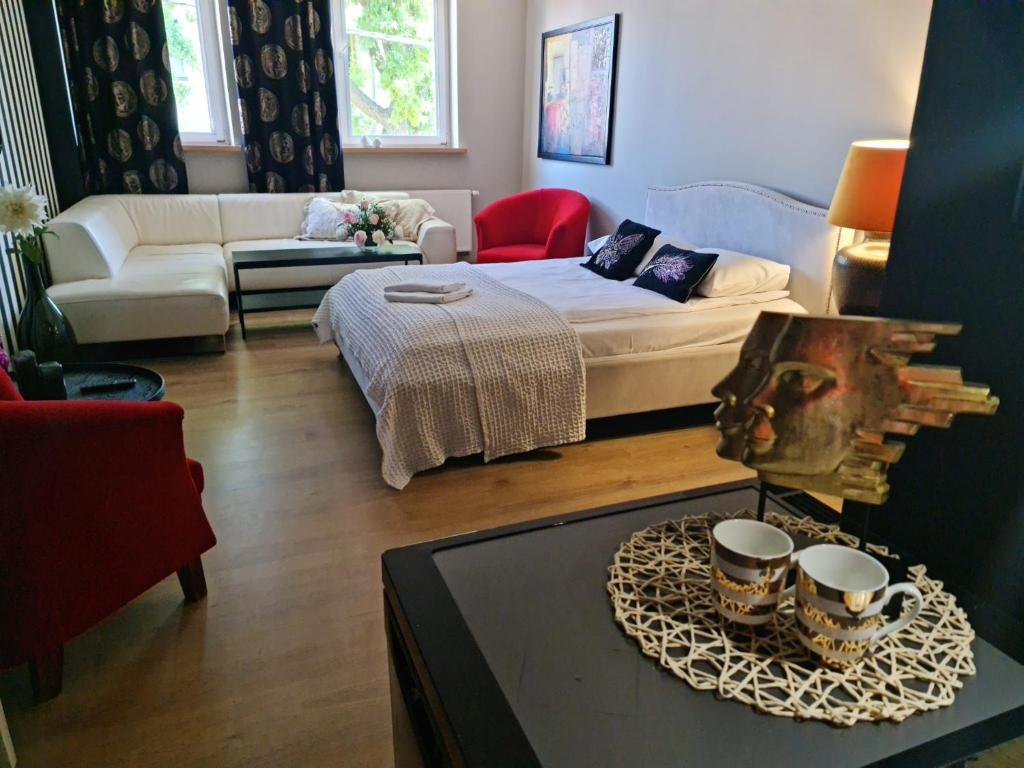 een woonkamer met een bed en een salontafel bij Pod Beczką in Augustów