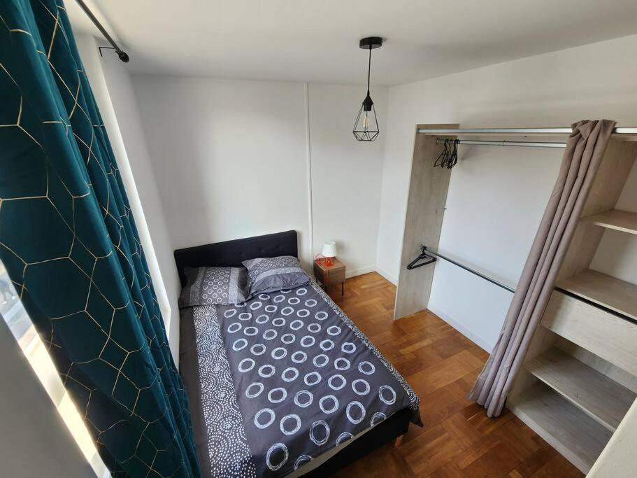 a bedroom with a bed in a small room at L&#39;Escale Lafayette - Appartement Rive Gauche in Rouen