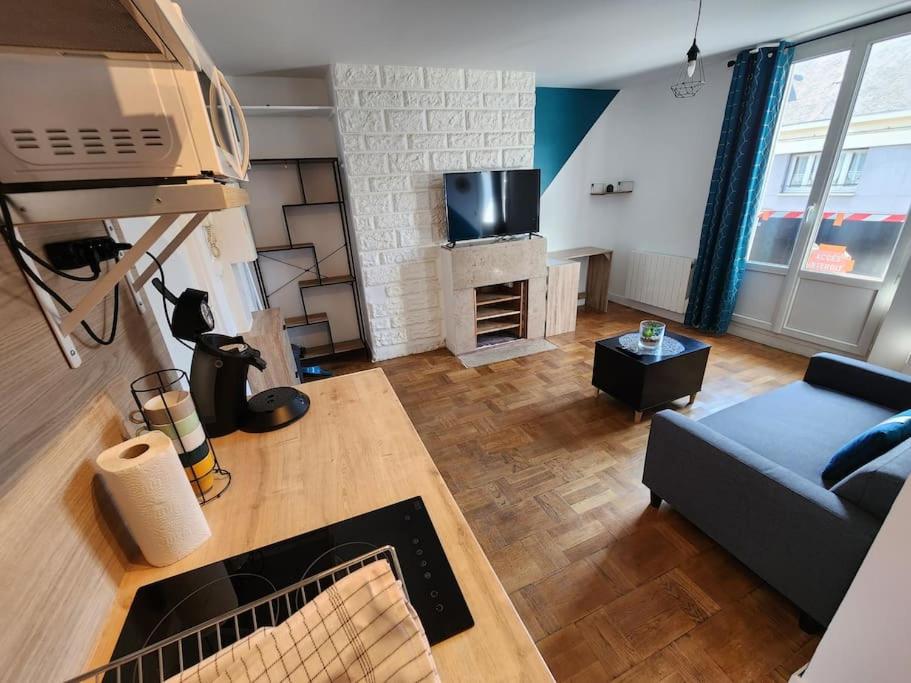 a living room with a couch and a tv at L&#39;Escale Lafayette - Appartement Rive Gauche in Rouen