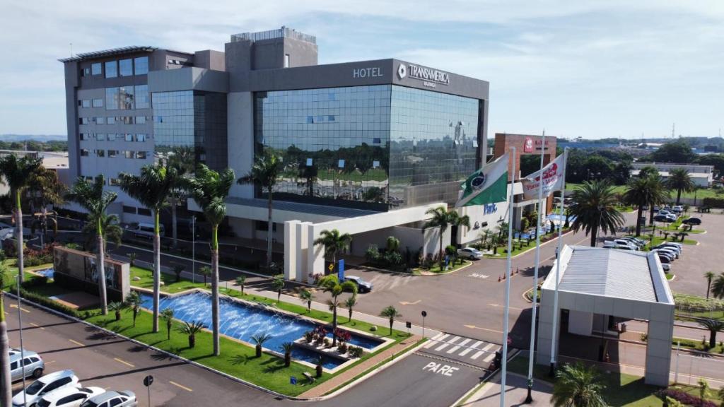 a large building with a pool in front of a street at Transamerica Executive Maringá in Maringá