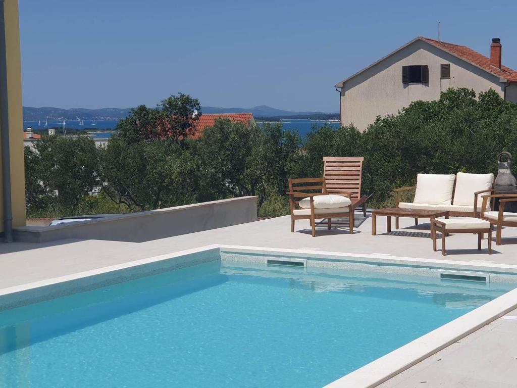 una piscina con due sedie e un tavolo di Relax House a Drage