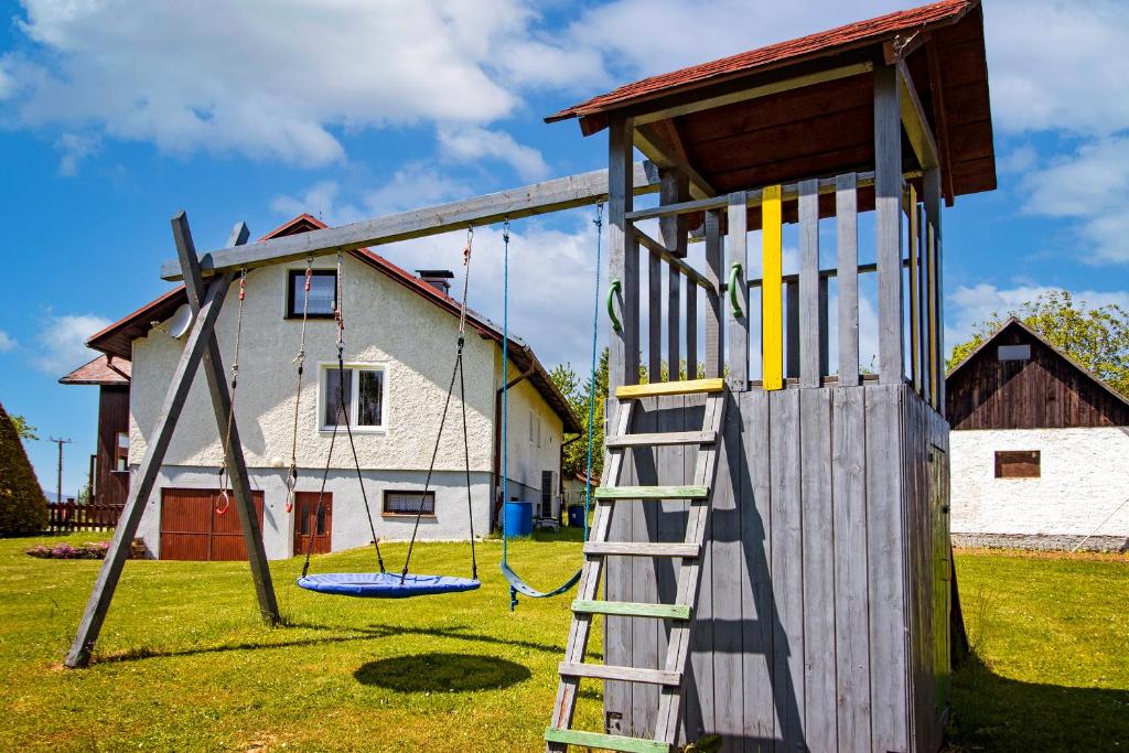 un parque infantil con estructura de madera y escalera en Chalupa Anežka, en Frymburk