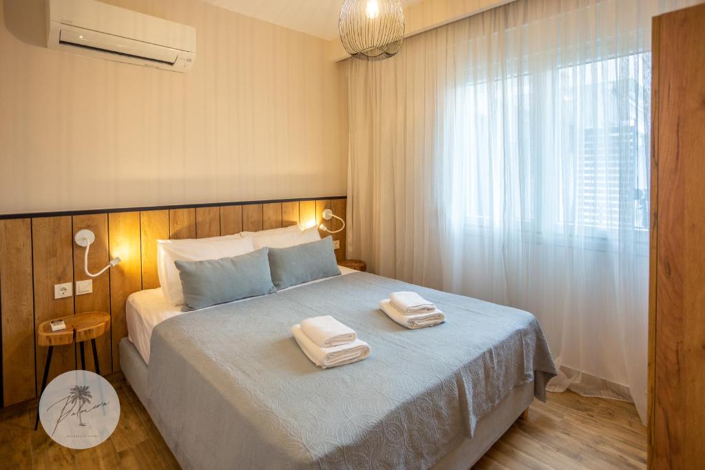 a bedroom with a bed with two towels on it at PALMERA STUDIOS in Ofrínion