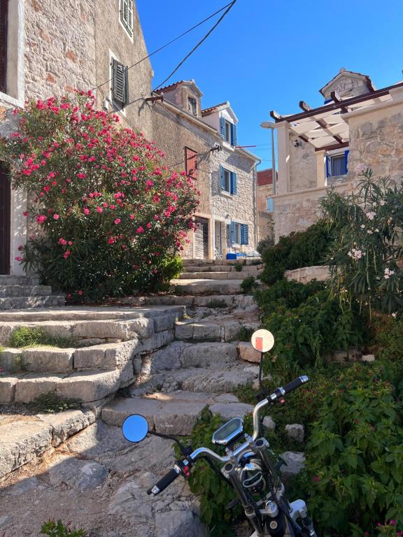 una motocicleta estacionada en un conjunto de escaleras de piedra en Kamena Kuca Kaprije, en Kaprije