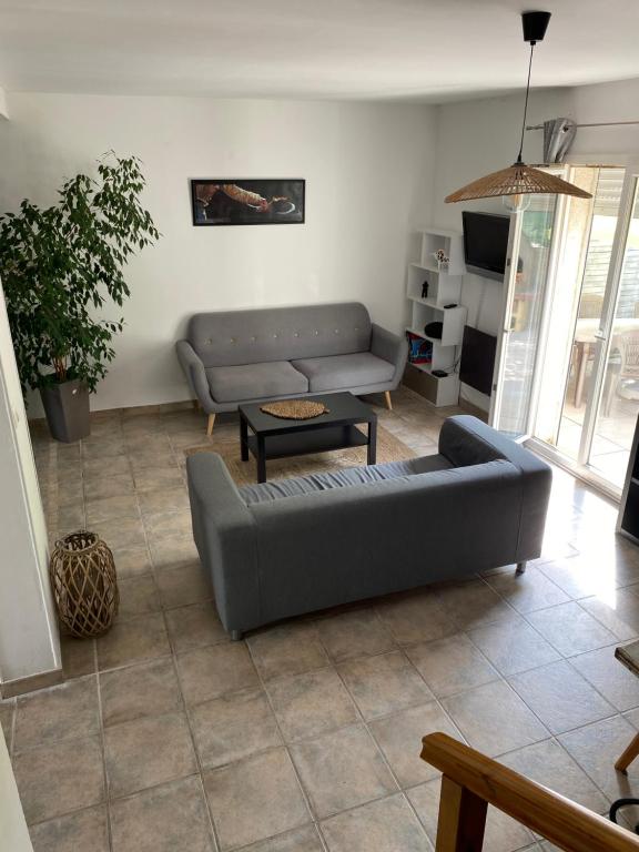 - un salon avec un canapé et une table dans l'établissement Charmante villa dans un lotissement très calme, à Béziers
