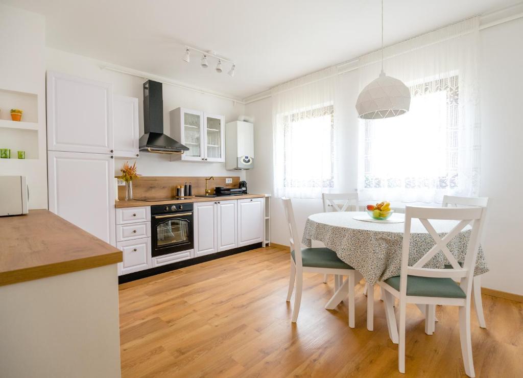 een keuken met witte kasten en een tafel en stoelen bij Tonka Apartment in Pula