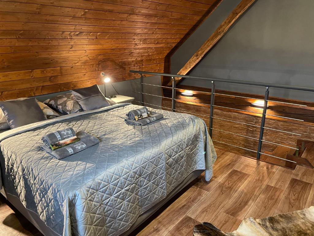 a bedroom with a bed and a wooden wall at SG chalupa ŠTIKOV - Podkrkonoší - s celoročním privátním wellness in Nová Paka