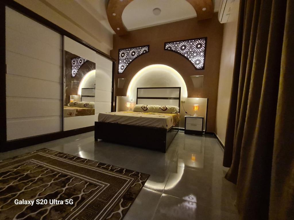 1 dormitorio con 1 cama en una habitación con ventanas en Moon Adam hostel en ‘Ezbet Abu Ḥabashi