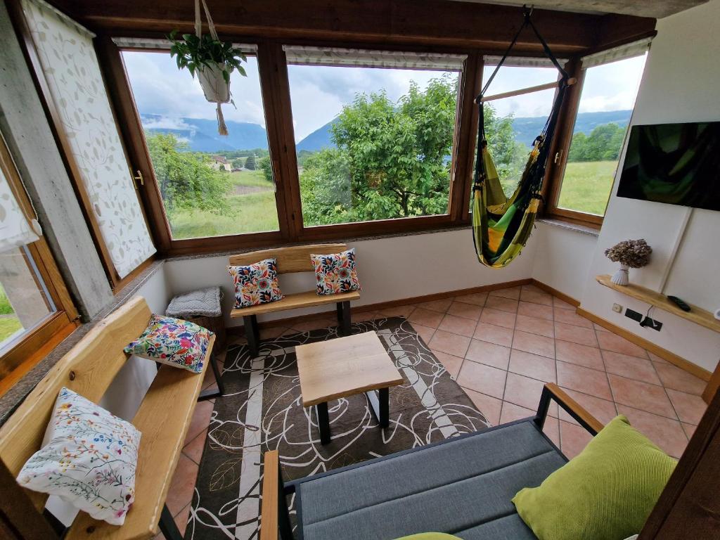 - un salon avec un canapé, des chaises et des fenêtres dans l'établissement La Veranda Alpago, à Pieve dʼAlpago