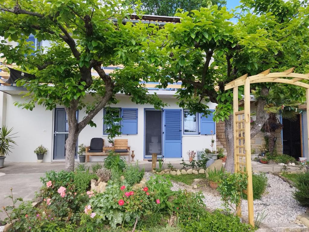 una casa con una puerta azul y un jardín en Apartma Salvia-Guest House en Lucija