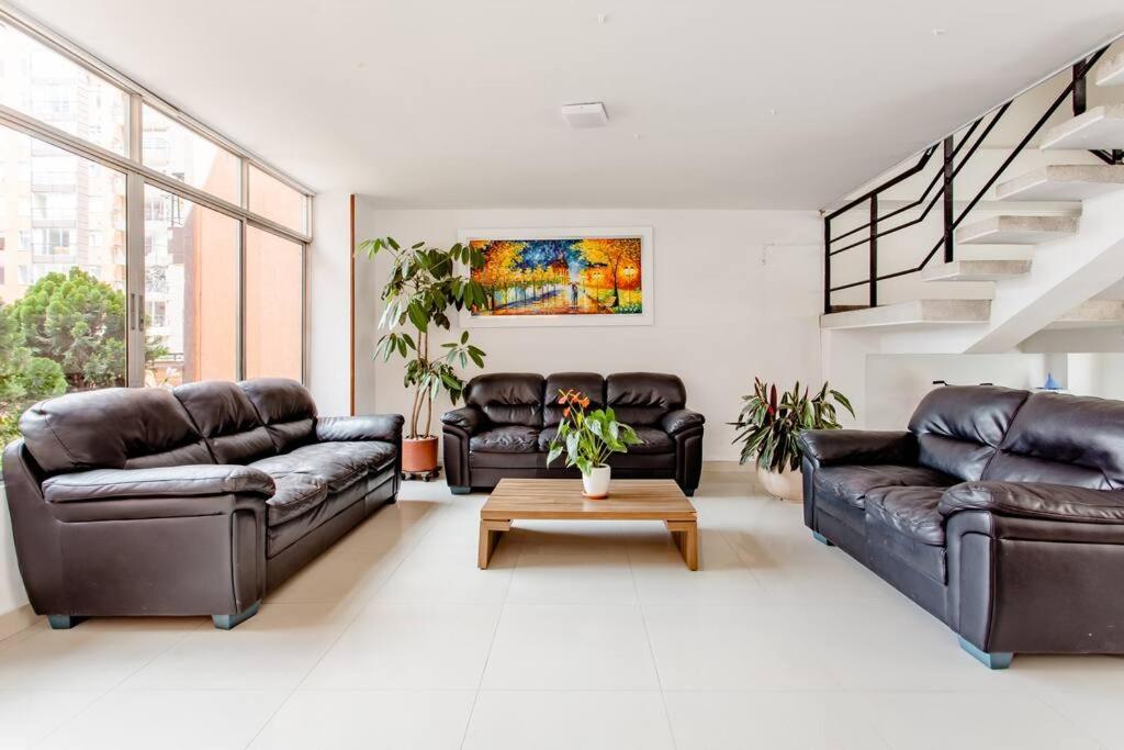 a living room with two leather couches and a table at Acogedora habitación en un punto central de Bogotá in Bogotá