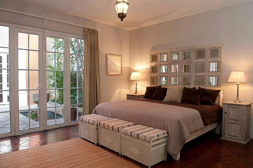 Un dormitorio con una cama grande y una ventana grande. en Casa Robelina 4bd+4bths. Center., en San Miguel de Allende