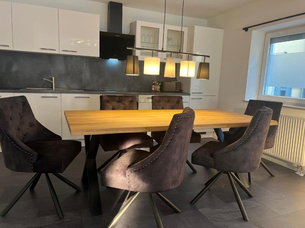 una cucina con tavolo e sedie in legno di Apartment für 6 Crailsheim Zentrum Netflix 300 Mbit Wlan a Crailsheim