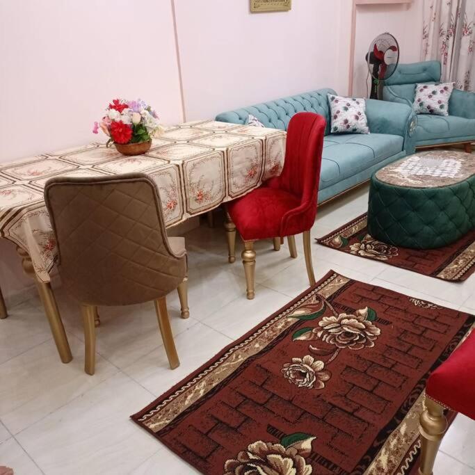 a living room with a table and chairs and a couch at Apt à Alexandrie cleopatra families only, KEMET in Alexandria