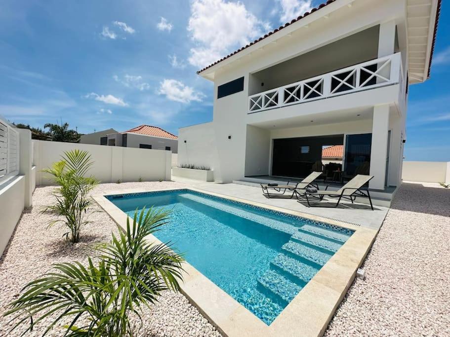a swimming pool in front of a house at Villa Vista Montaña in Willemstad