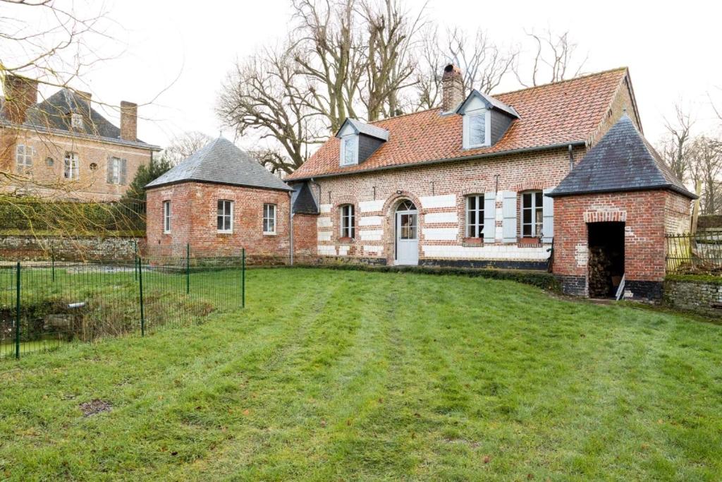 an old brick house with a large grass yard at Château D'arry Maison de Vacance in Arry