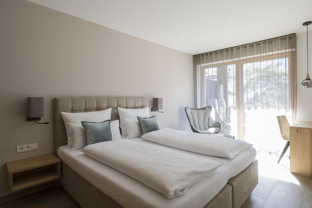 - une chambre avec un grand lit blanc et une fenêtre dans l'établissement Residence Sonja - Apartment Picea, à Rablà