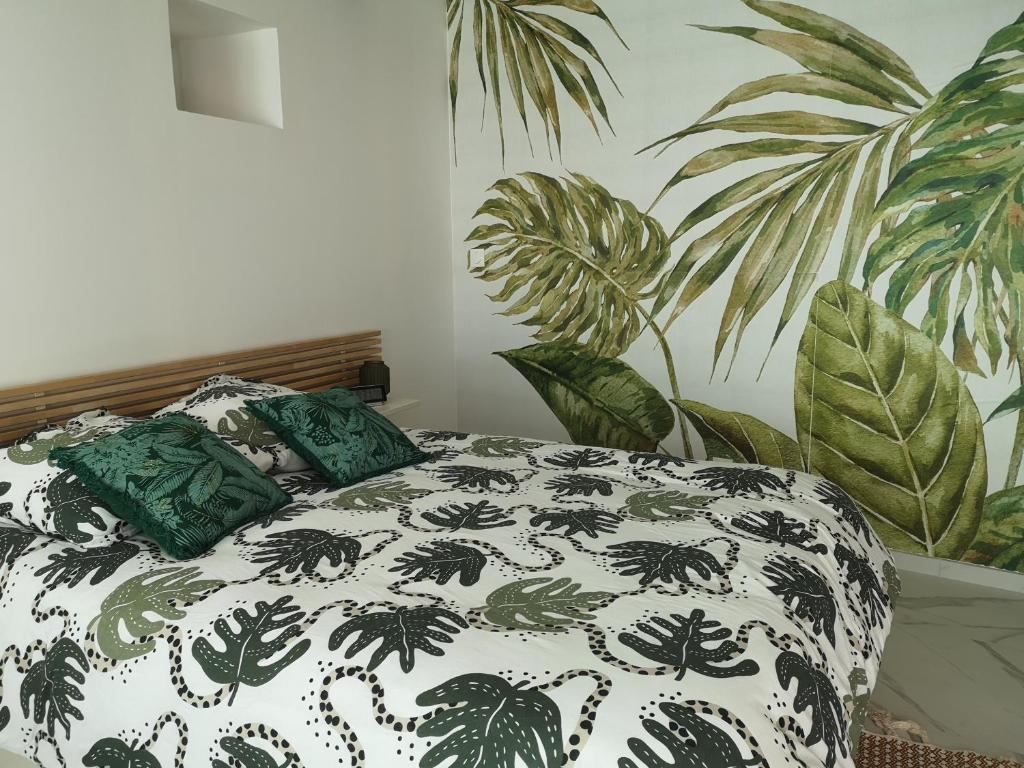 1 cama con sábanas blancas y negras y almohadas verdes en Appartement face Métro B hôpital Lyon Sud, en Pierre-Bénite