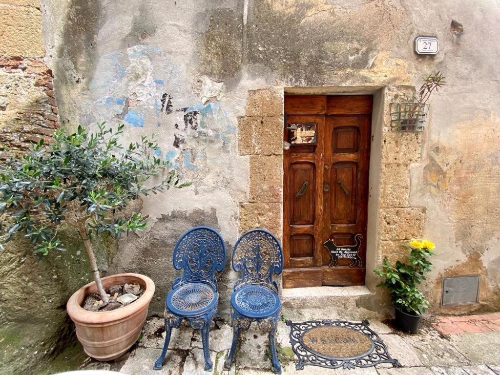 dwa krzesła siedzące przed budynkiem z drzwiami w obiekcie Casa Marghera House Winery Bikes w mieście Pitigliano