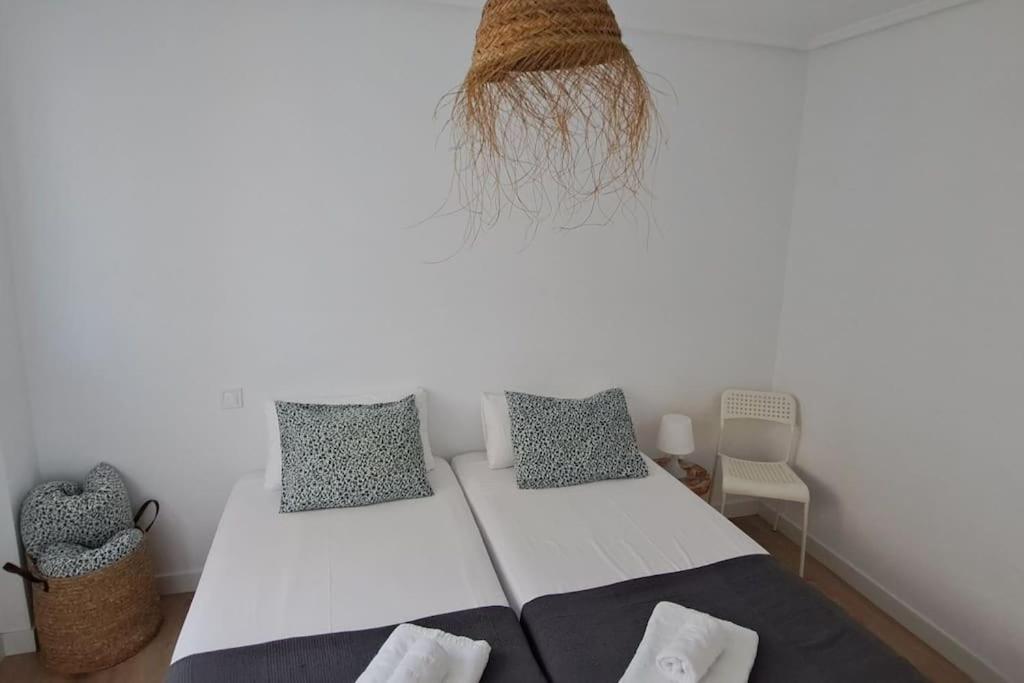 sypialnia z białym łóżkiem z 2 poduszkami w obiekcie Apartamentos La Arena Zierbena 201 w mieście Campomar