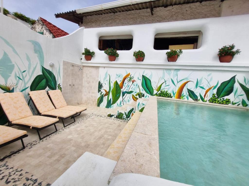 una piscina con un mural en el lateral de un edificio en Casa Cordoba Román en Cartagena de Indias