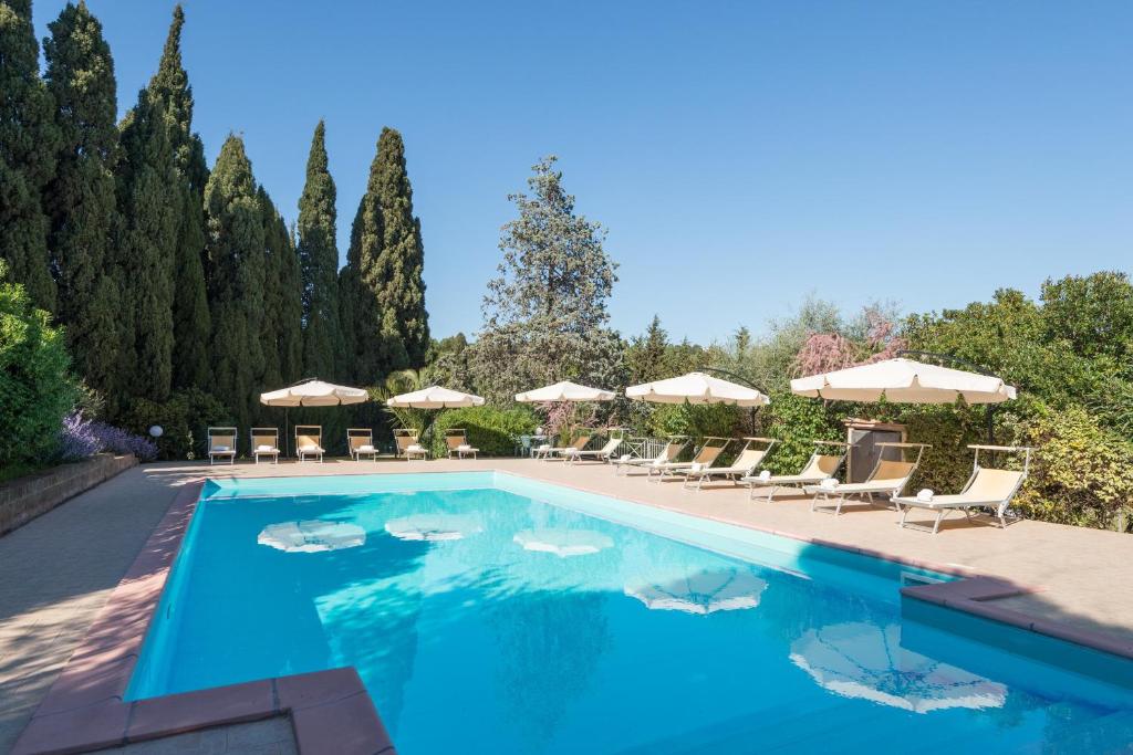 una piscina con sillas y sombrillas en B&B Villa il Poggetto, en Venturina Terme
