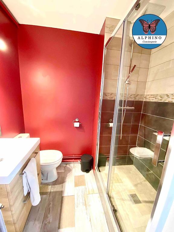 a red bathroom with a toilet and a shower at Le Nid Douillet, proche du centre-ville in Limoges
