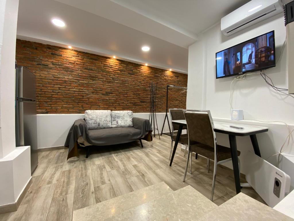 uma sala de estar com uma mesa e cadeiras e uma televisão em Guest House GML-1 em Tbilisi