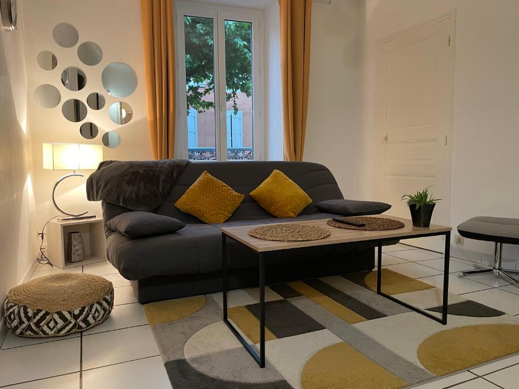 ein Wohnzimmer mit einem Sofa und einem Tisch in der Unterkunft T2 plein centre au 1er étage avec parking privé in Millau