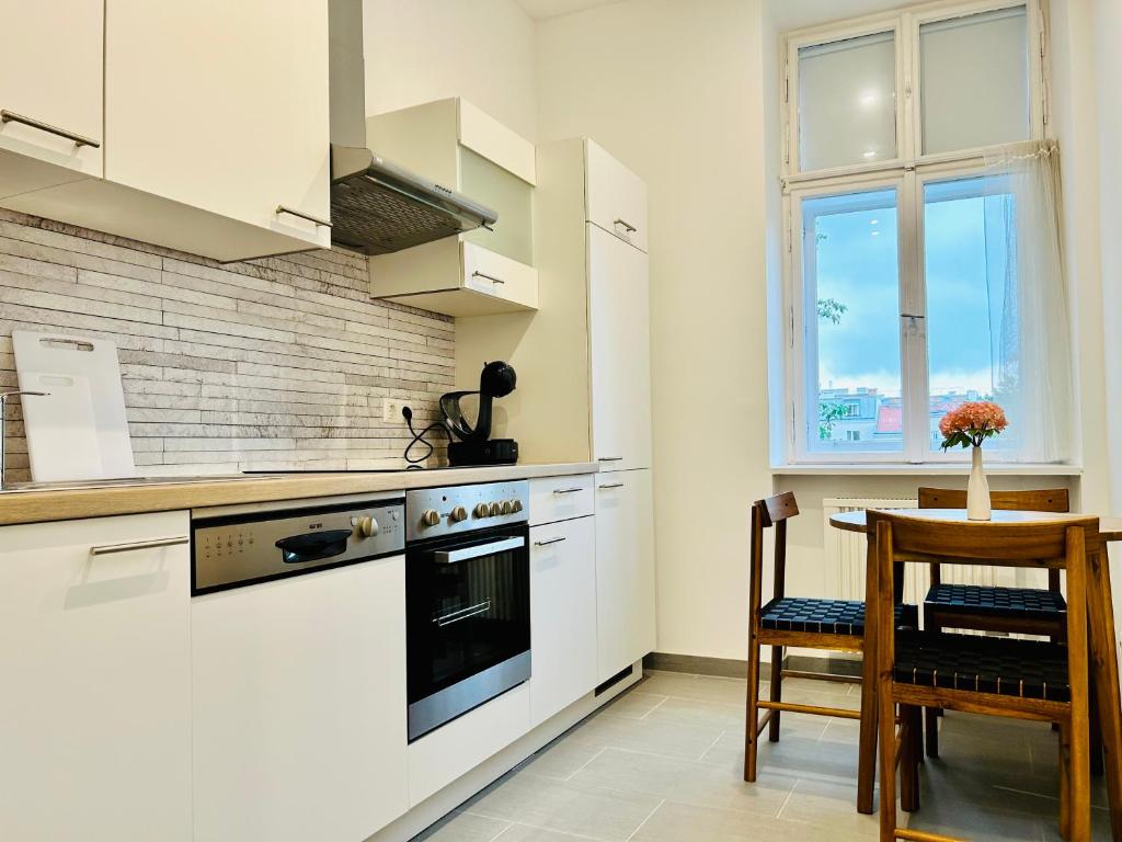 uma cozinha com um fogão, uma mesa e uma janela em Cosy & Central - Free Parking - Free Netflix em Viena