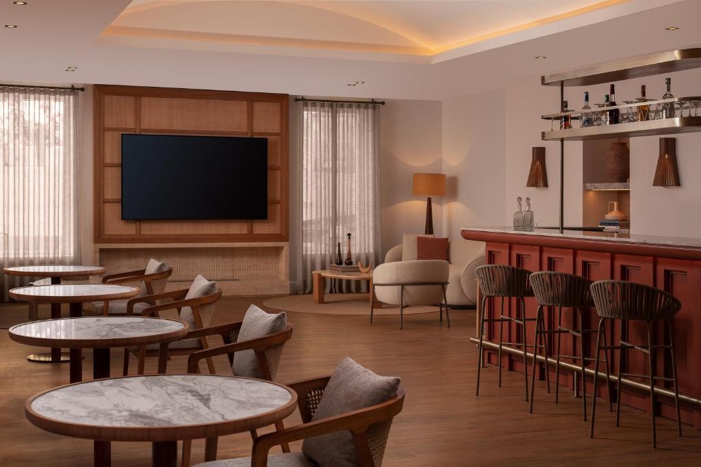 a hotel room with tables and chairs and a flat screen tv at Doria Hotel Bodrum-City Center in Bitez