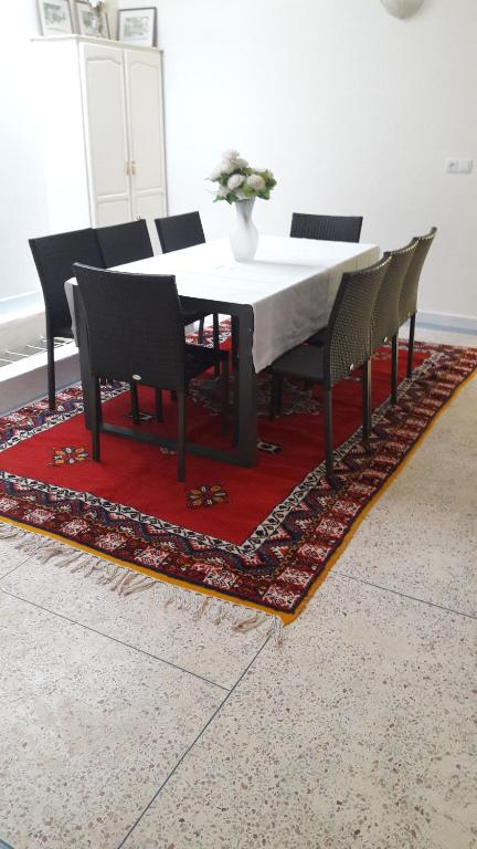 mesa de comedor y sillas en una alfombra en appartement kalaat mgouna, en Irmina