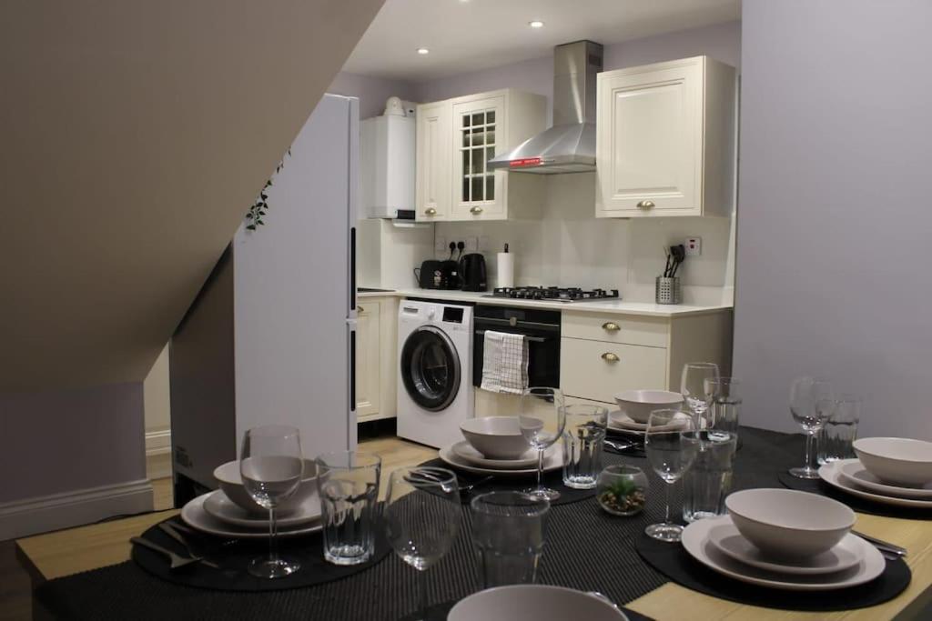 a kitchen with a table with plates and wine glasses at 5 star Apartment in London
