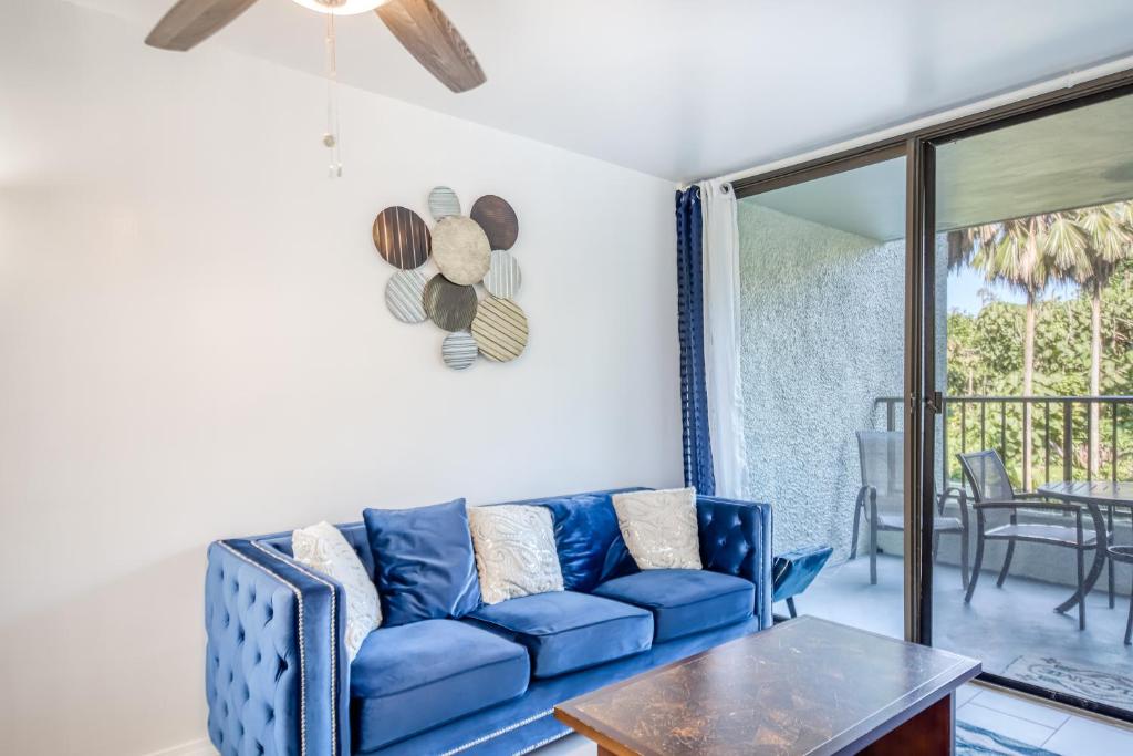 sala de estar con sofá azul y mesa en Maunaloa Shores 109, en Hilo