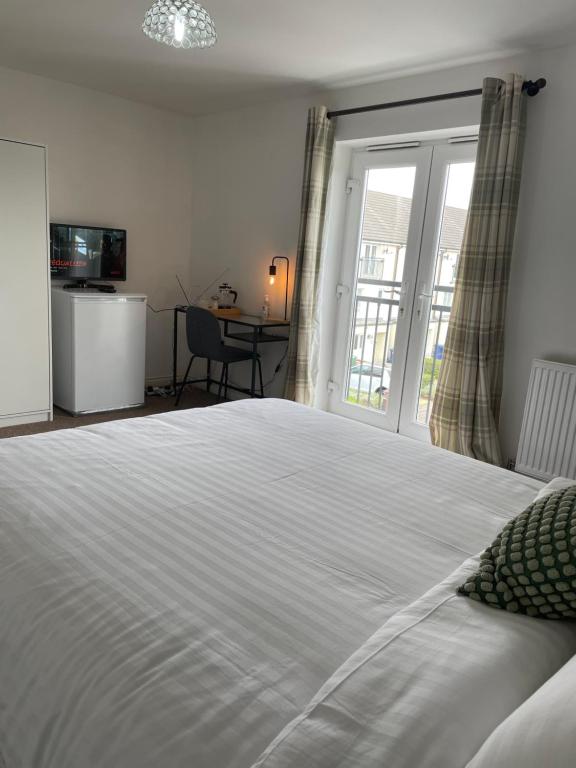 Schlafzimmer mit einem großen weißen Bett und einem Fenster in der Unterkunft Luxury Rooms In Furnished Guests-Only House Free WiFi West Thurrock in Grays Thurrock