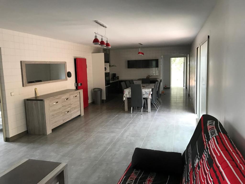 un salon avec un canapé et une télévision et une cuisine dans l'établissement Maison plain pied 130m2, à Conca