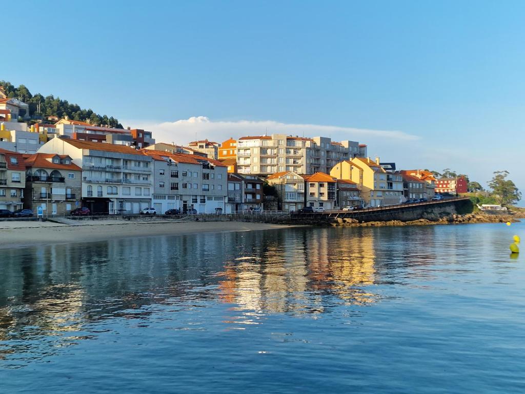 a group of buildings on the shore of a body of water at Apartamento Raxobrisamar in Raxo