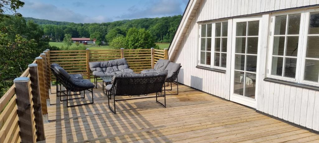 um deque com cadeiras e uma mesa numa casa em Lägenhet på hästgård em Ljungbyhed
