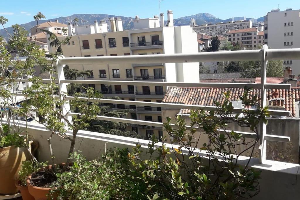 einen Balkon mit Topfpflanzen und Gebäuden in der Unterkunft Logement au coeur de Marseille in Marseille